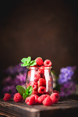 Raspberries in a Cup on a dark background. Summer and healthy food concept. Background with copy space. Selective focus.