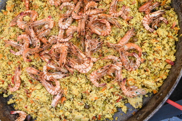 Seafood paella cooked in a large pan wok, street food festival. Mexican fiesta national day