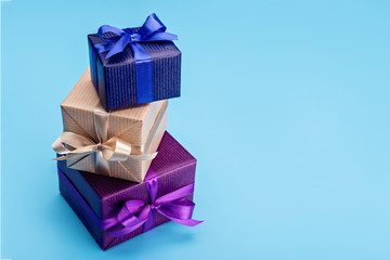 Set of vertical boxes with gifts and surprises, packed in elegant paper. Copy space, blue background.