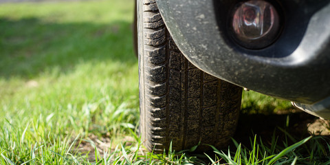 SUV wheels on green summer grass.