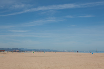 Fototapeta na wymiar Deserted beaches during siesta and quarantine without people. Blue sky and bright sun and white sand. Valencia, Spain