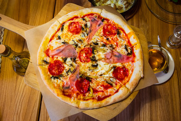 Delicious pizza with pepperoni and sausages on wooden table, top view
