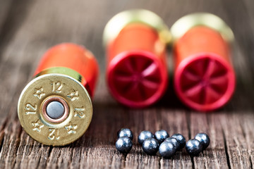 Selective approach of 12-gauge shotgun cartridges used for hunting, on a wooden table