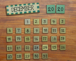 Vintage calendar 2020 handmade from wood on wooden wall, on December of the year 2020.