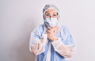 Middle age nurse woman wearing protection coronavirus equipment over white background shouting and suffocate because painful strangle. Health problem. Asphyxiate and suicide concept.
