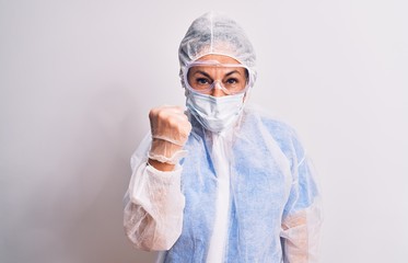 Middle age nurse woman wearing protection coronavirus equipment over white background angry and mad raising fist frustrated and furious while shouting with anger. Rage and aggressive concept.