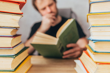 A man with a book between stacks of books - passionate about the novel - classic literature