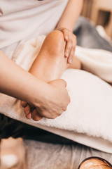Obraz na płótnie Canvas Foot massage in the massage parlor - female hands massage the female feet - beauty and health