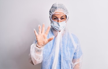 Middle age nurse woman wearing protection coronavirus equipment over white background showing and pointing up with fingers number five while smiling confident and happy.