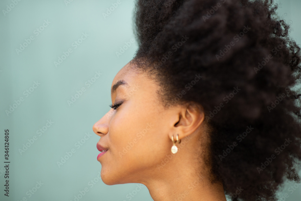 Wall mural profile portrait beautiful young african american woman with afro hair and eyes closed by green background