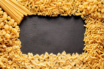 Heap of various raw pasta or macaroni in different types and shapes with copy space for text