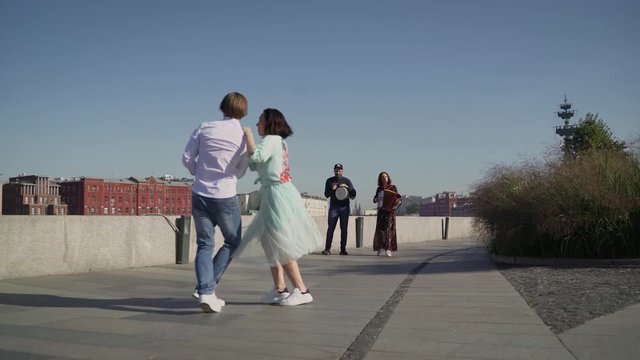A young couple dancing a Spanish dance to live music. Young couple dancing outdoors under the button accordion and drum tomtom