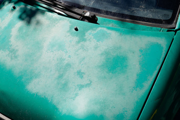 car green painted completely faded engine hood with paint worn over time