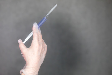 The nurse holds a syringe in her hand and prepares to give the patient an injection