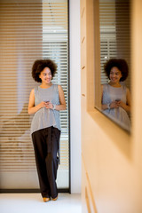Smiling african american businesswoman using mobile phone in office