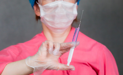 The nurse holds a syringe in her hand and prepares to give the patient an injection