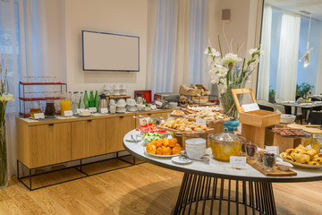 Breakfast served on round buffet table in hotel restaurant