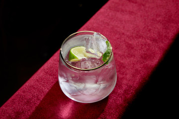 High angle view of mojito with lime, mint and ice cubes in old fashioned glass isolated on black
