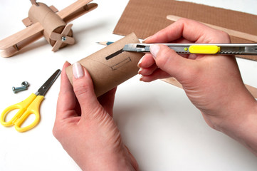 How to make airplane. Hand made toy,zero waste from toilet paper roll and popsicle sticks. For kids and parents. Step 2, cut out hole for wings.