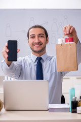 Young male shopaholic in e-commerce concept