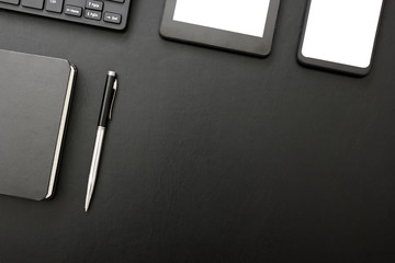 Black desk office with laptop, smartphone and other work supplies with cup of coffee. Top view with copy space for input the text. Designer workspace on desk table essential elements on flat lay