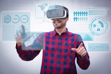 Content man using virtual reality headset and virtual statistics. Cheerful bearded man in checkered shirt moving hands and using VR headset on grey background. Technology concept