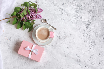 flat lay coffee Cup a sprig of lilac and a gift pink box. Good morning background, place for text