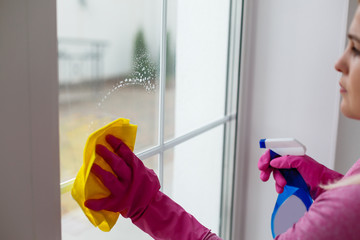 Woman cleaning a window with yellow cloth
