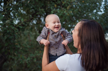 Fototapeta premium The baby laughs happily in maternal hands. Fun play with a kid