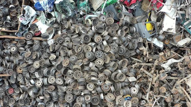 Aerial drone video of destroyed broken car wheels and scrap metal. Drone view on scrapyard