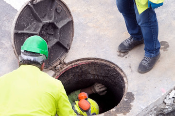 sewer  utility worker for cleaning and repairing sewerage pipes  in construction site