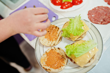 Сooking burgers in the kitchen at home during quarantine time.