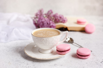 Obraz na płótnie Canvas A Cup of morning coffee, a bowl of lilac, macaroni, on a light background. Postcard good morning
