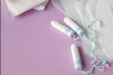 Menstrual pads and tampons on red background.