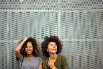 two young african american woman laughing with afro hair