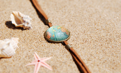 travel background concept. globe, shells and sand