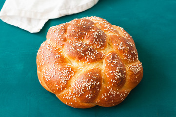 Homemade round challah with sesame seeds. Traditional jewish pastry.