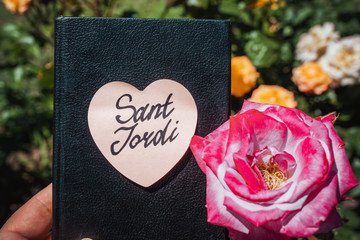 Hardcover book with an inscription Sant Jordi next to a rose