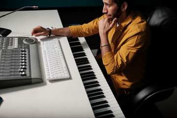 Man working on music controllers at home studio