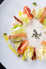Ceasar salad with bacon served on a white plate