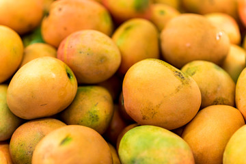 Close up of fresh mangos at food street market. Juicy mango fruit background