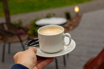 Mug of coffee in a summer cafe. Luxury rest.