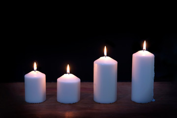 Fototapeta na wymiar Close-up of burning candles on black background..
