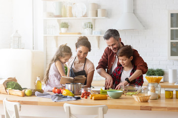 Happy family cooking together on kitchen with kids.  - obrazy, fototapety, plakaty
