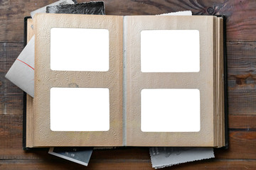 Open old photo album with place for photos on a wooden table. Isolated on white. - obrazy, fototapety, plakaty