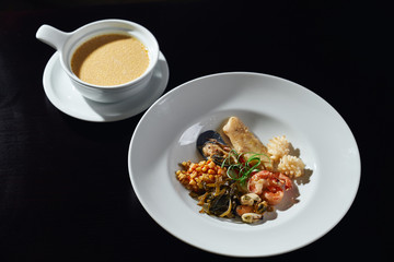 Plate of seafood and sauce on table.