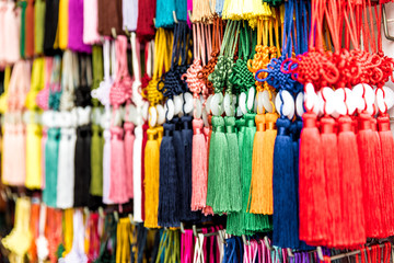 Rows of hand made Chinese lucky charms for sale hanging on street market in Chinatown. Pattern of Chinese knots