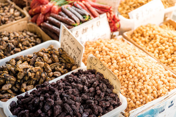 Dried snacks for sale in baskets with price tag. Oriental, crispy  snacks at street food market. Local asian food