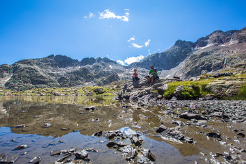 A couple sitting in the Ibones de Panticosa in the Pyrenees, Aragon. Spain