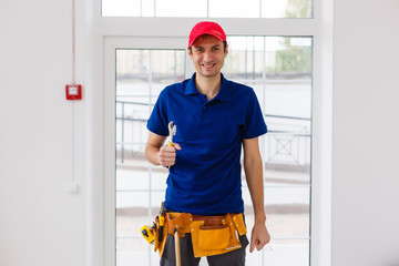Portrait of cheerful young worker posing looking at camera and smiling enjoying work